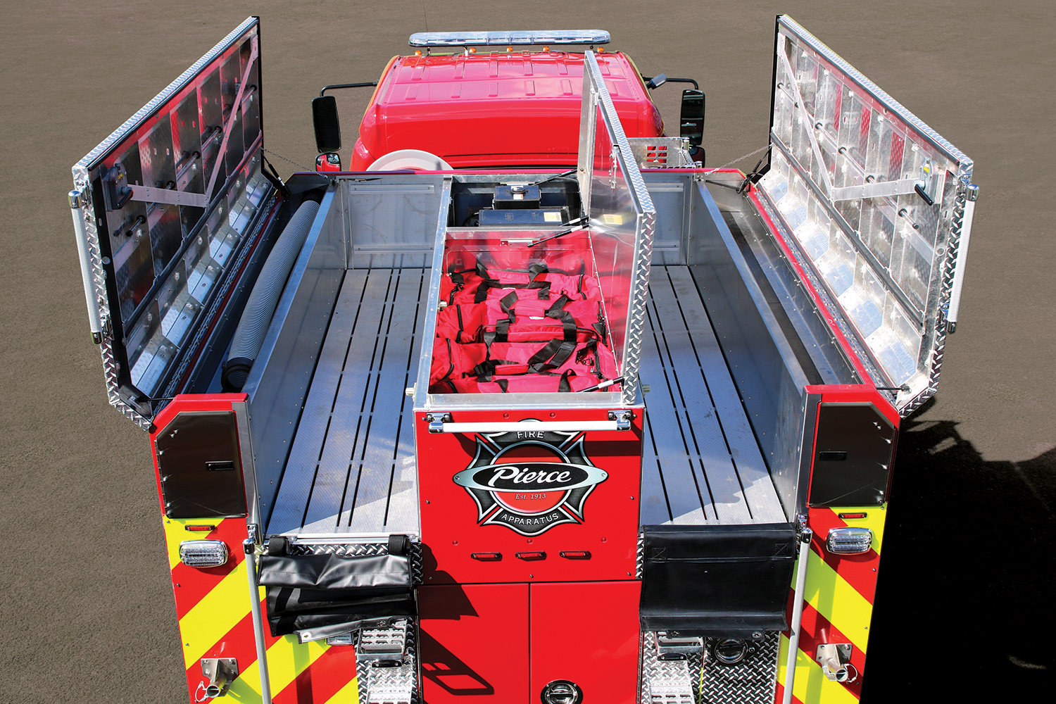Pierce BX™ Wildland Fire Truck with left and right hatch compartments open atop of the apparatus showing storage space. 