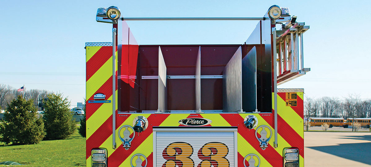 Pierce Pumper Fire Truck with a rear low hose bed parked outside on a sunny day. 