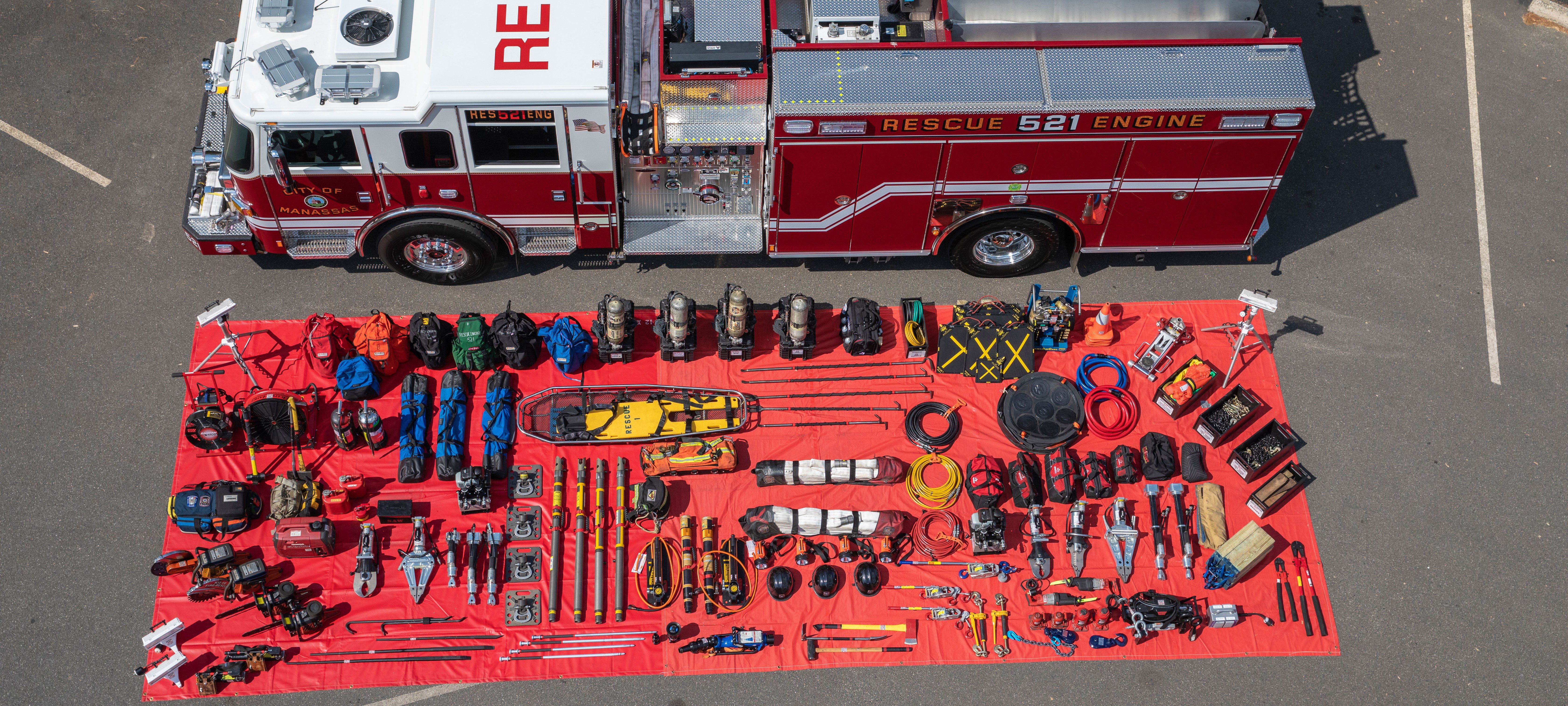 Pierce Pumper Fire Truck with fire rescue tools laid out beside the truck in a parking lot. 