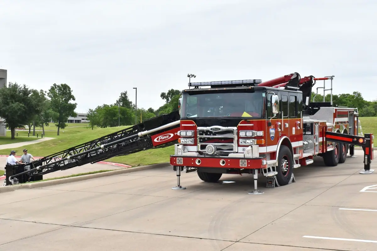 A Pierce Ascendant 100' Aerial Tower fire truck demonstrates below-grade ladder operations during a Road Rally event.