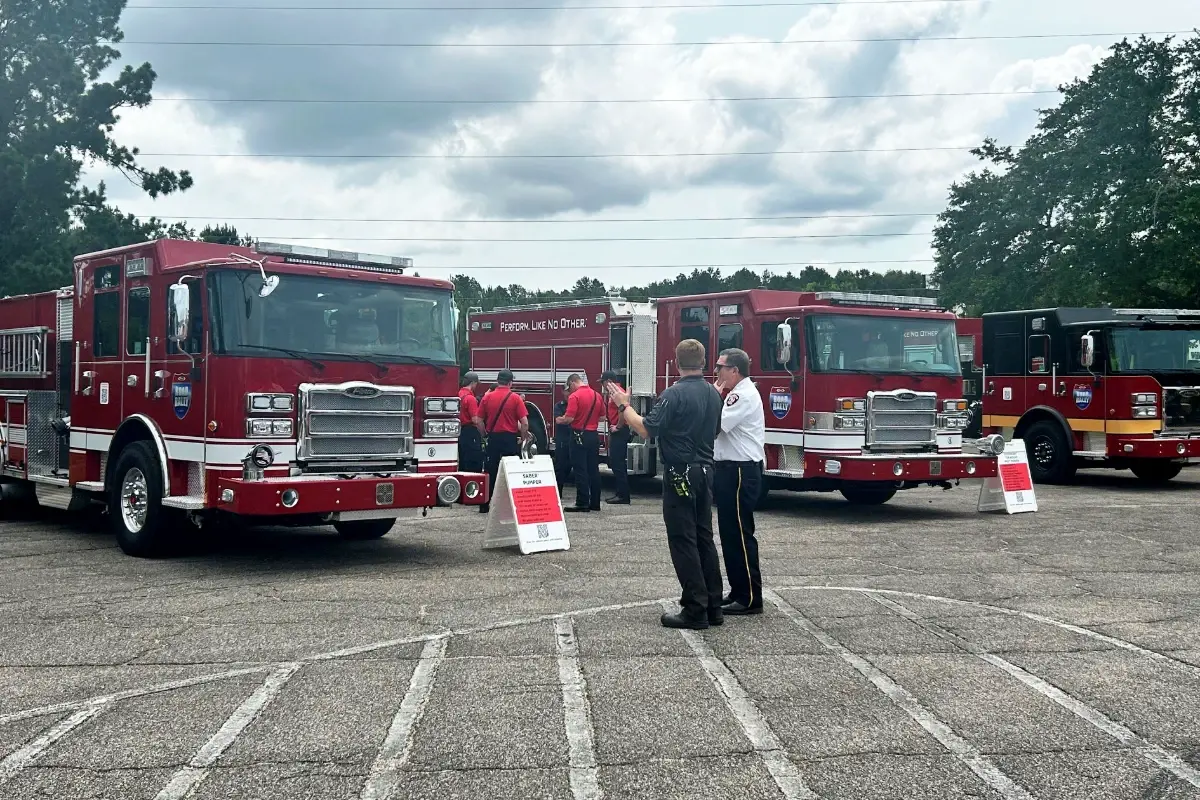 Firefighters inspect custom Pierce fire trucks, including a Saber Pumper, at a Road Rally event.