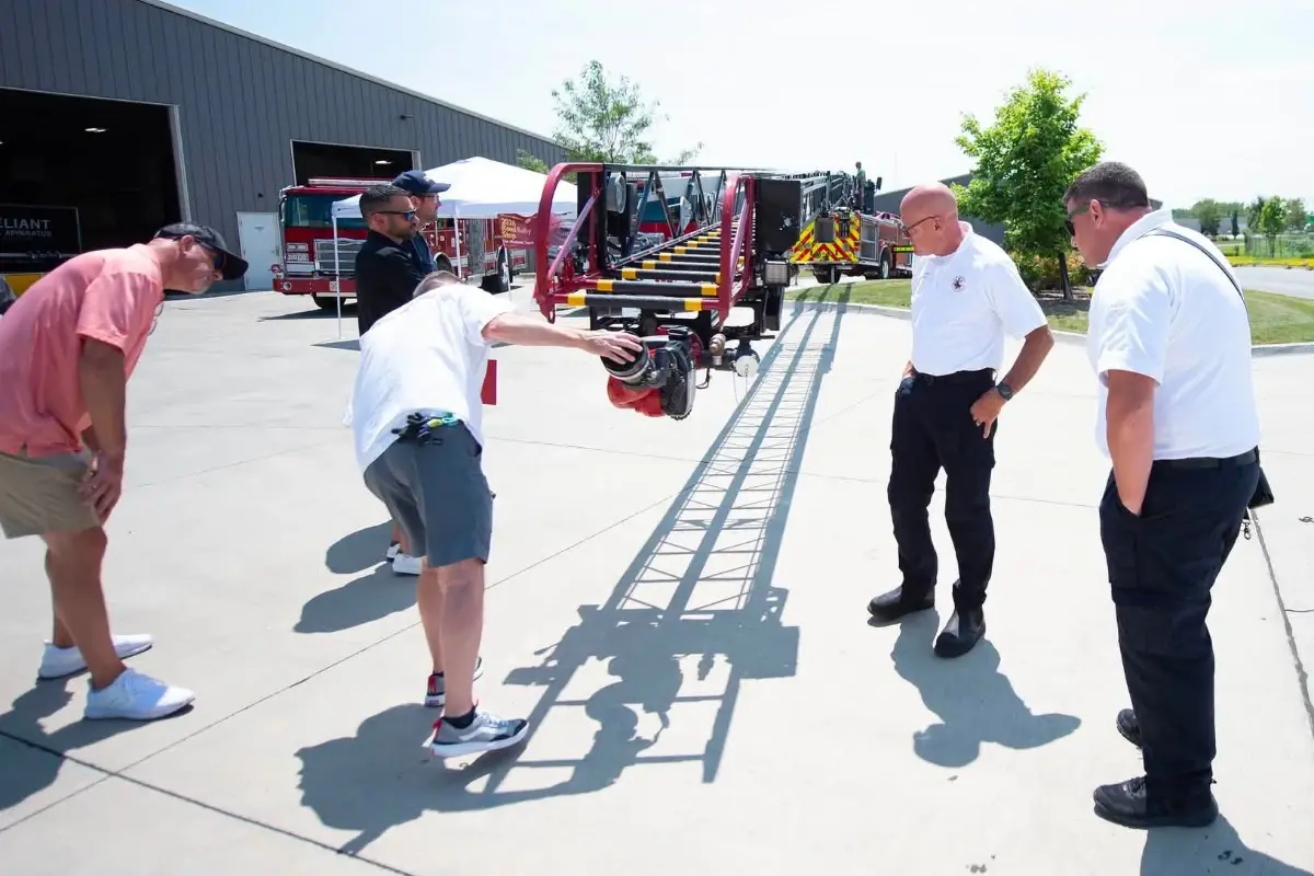 Firefighters examine an aerial ladder during a Pierce Road Rally event.