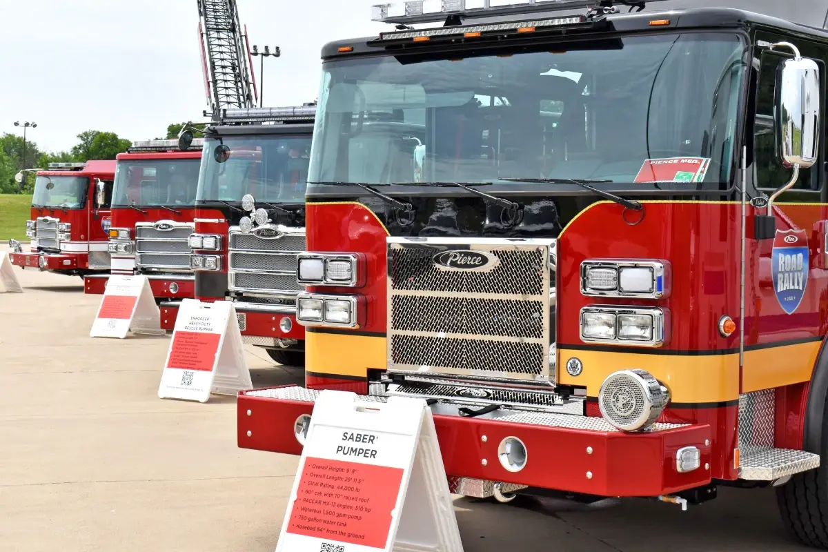 A lineup of Pierce fire trucks, including a Saber Pumper, on display during a Pierce Road Rally event.