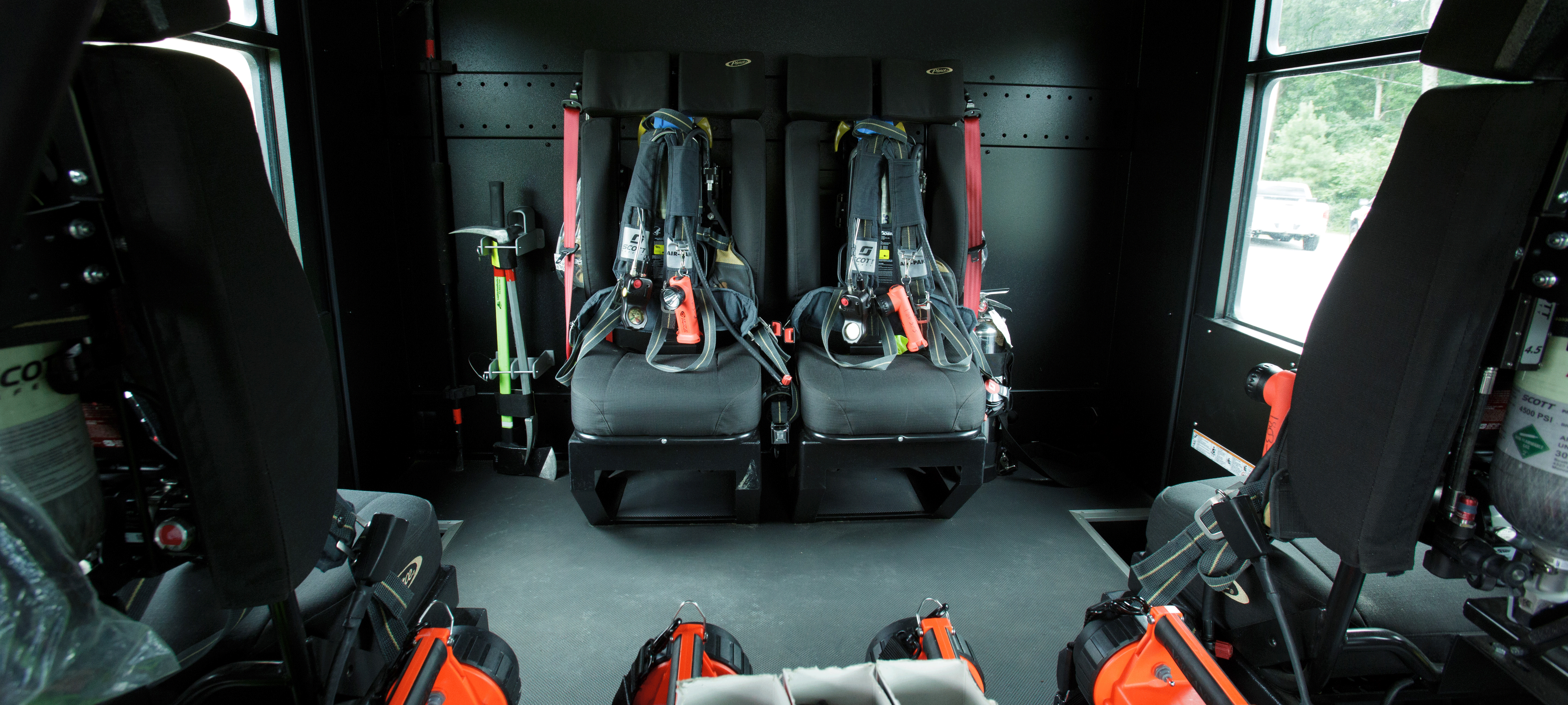 Interior of a Pierce Saber custom fire truck chassis with black interior and two grey rear seats. 