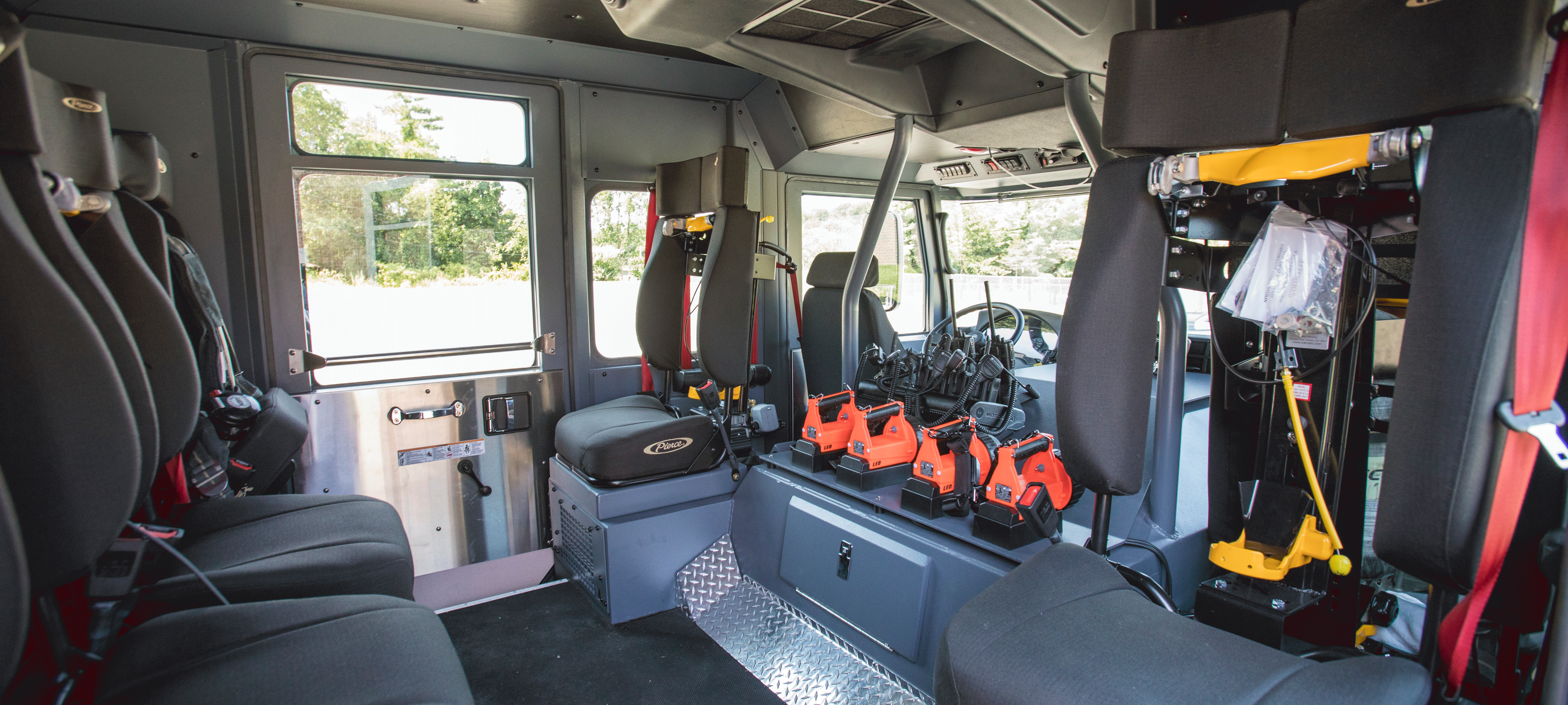 Interior chassis configuration with grey rear seating in a Pierce Saber custom fire truck. 