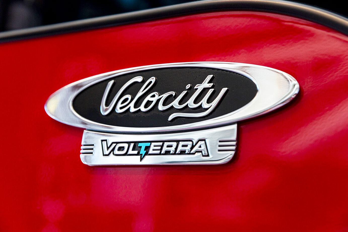 A logo on the side of a red door for a Velocity Volterra electric fire truck.