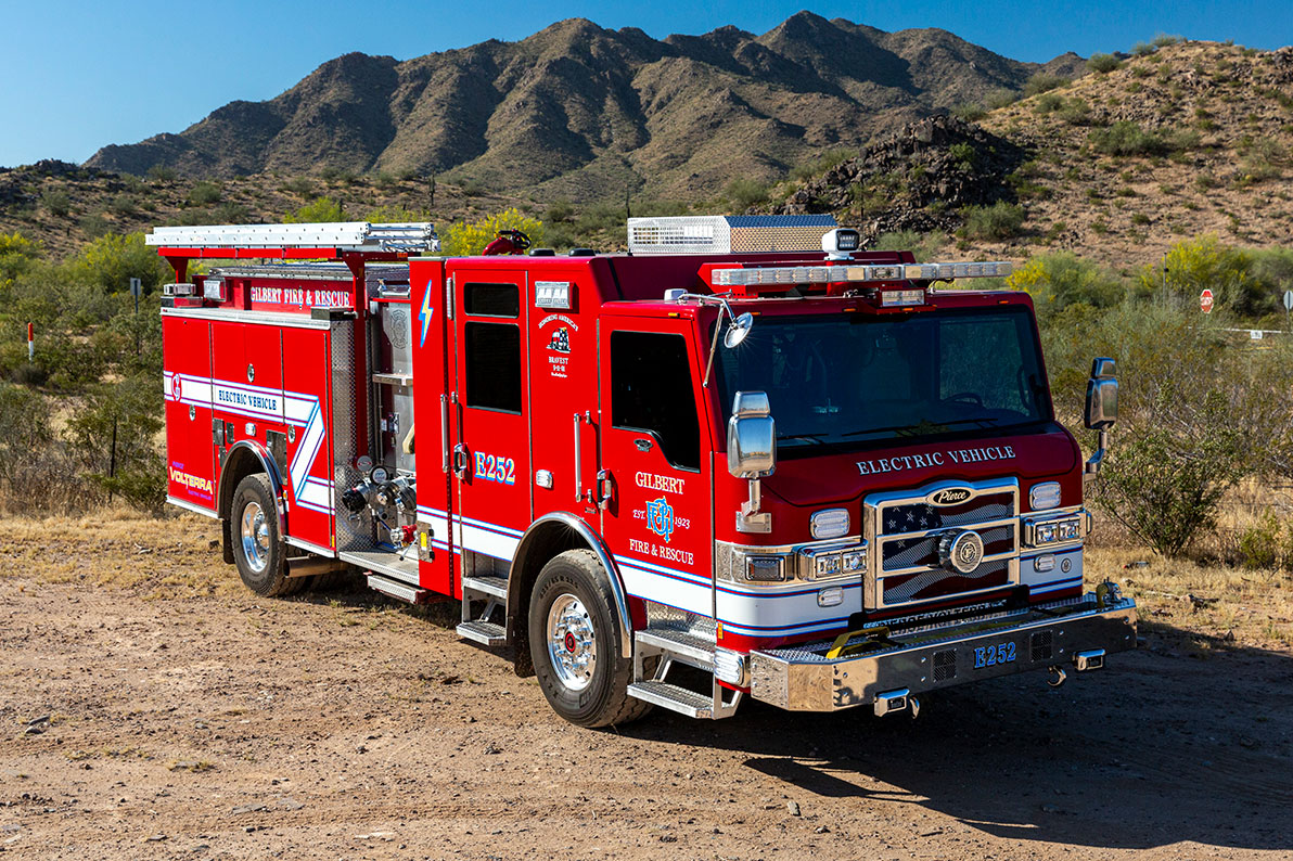 The front officers side of a Velocity Volterra Pumper parked in the desert with mountains behind it.