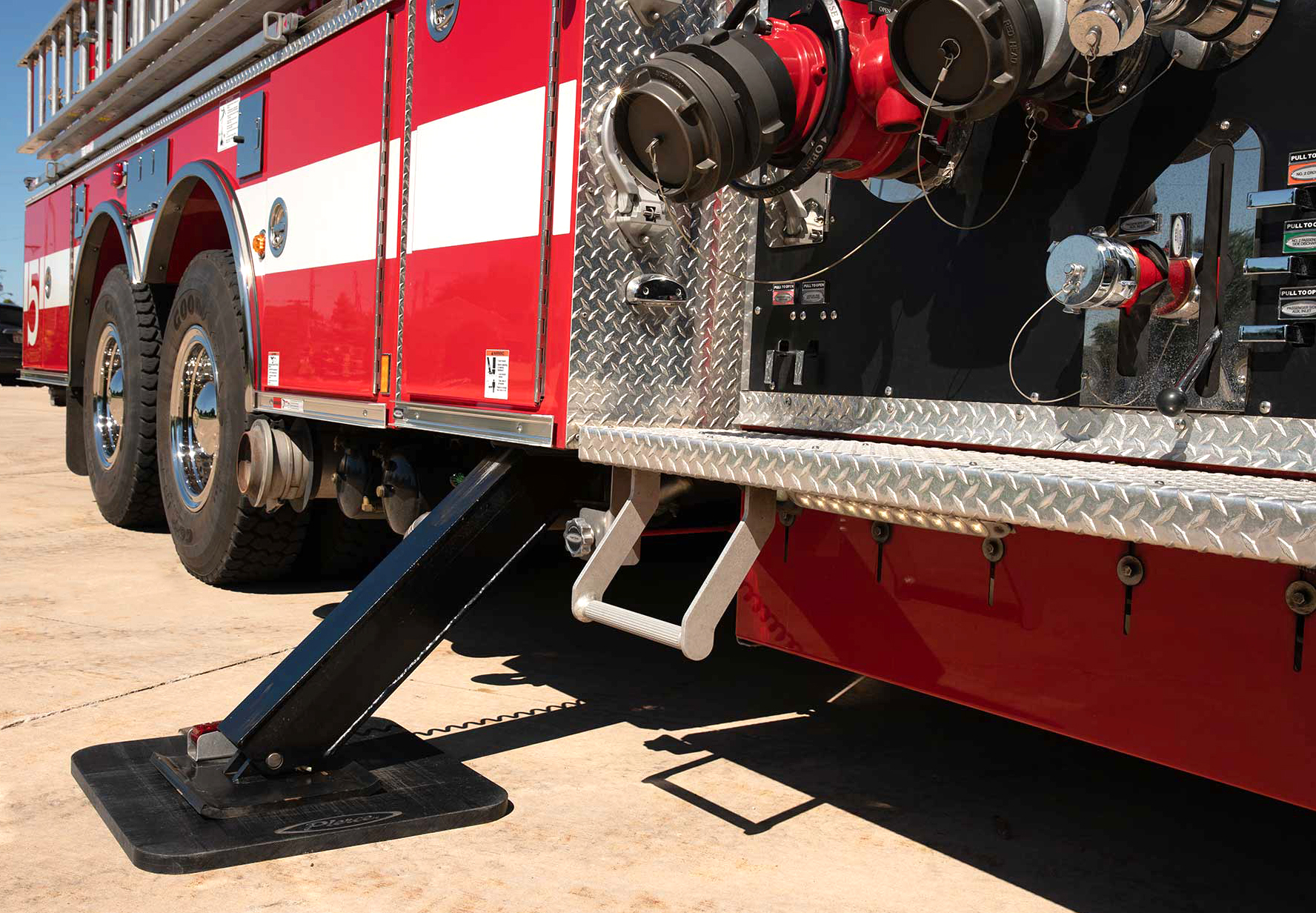 Pierce Fire Truck parked outside on a sunny day with its 11-foot stabilizers on the officer’s side of the apparatus. 