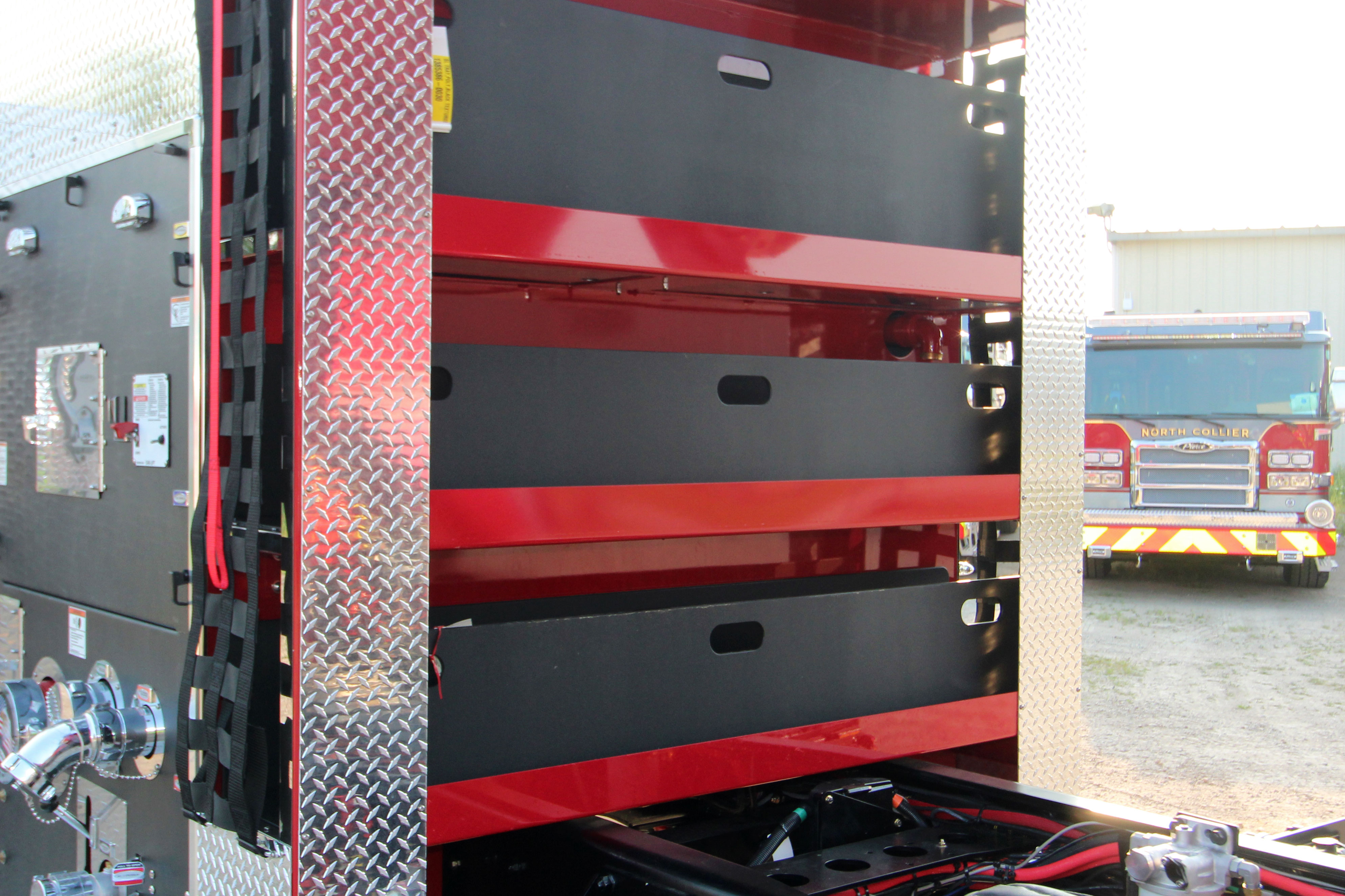 The speedlays of a fire truck with speedlay trays with the fire truck cab tilted up.