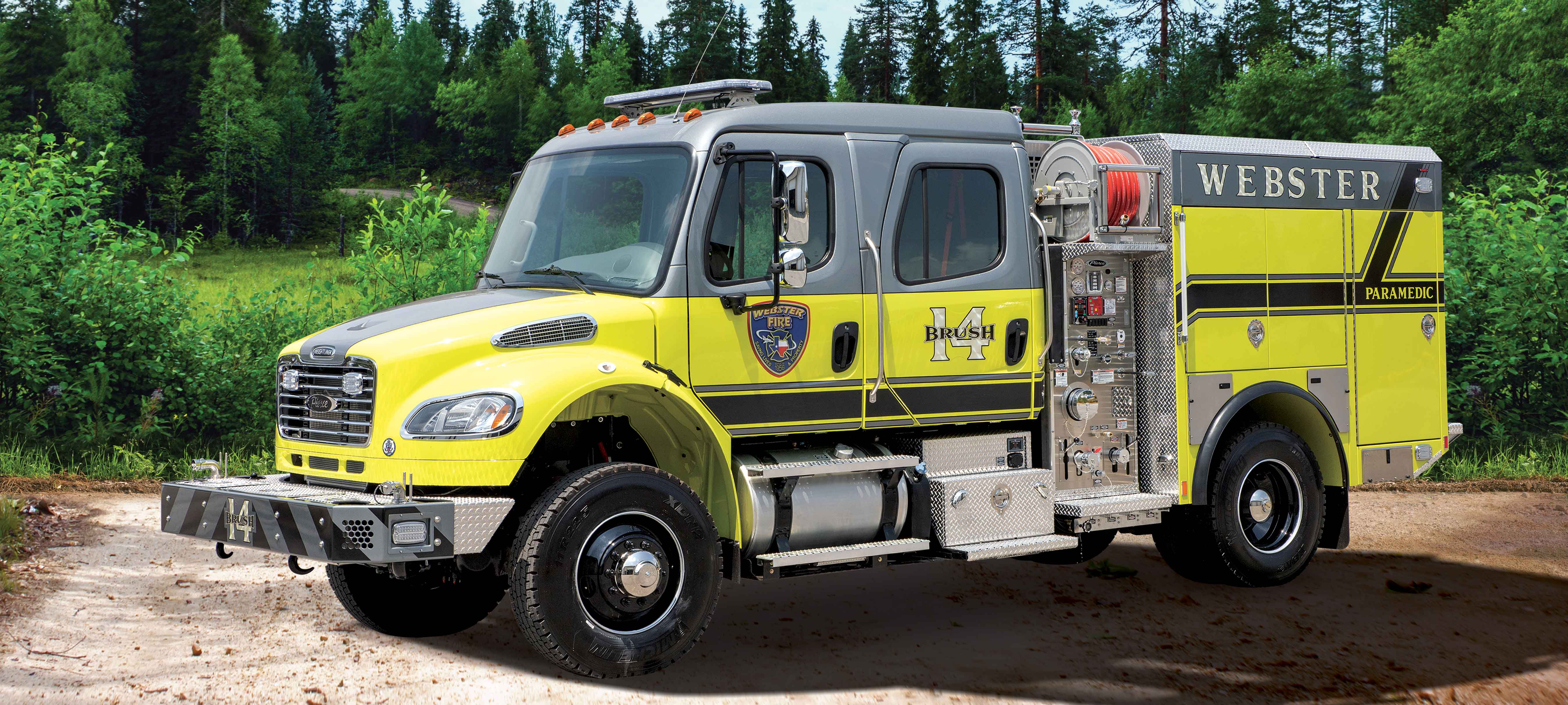 Pierce BX™ Wildland Fire Truck Pumper parked outside near trees. 