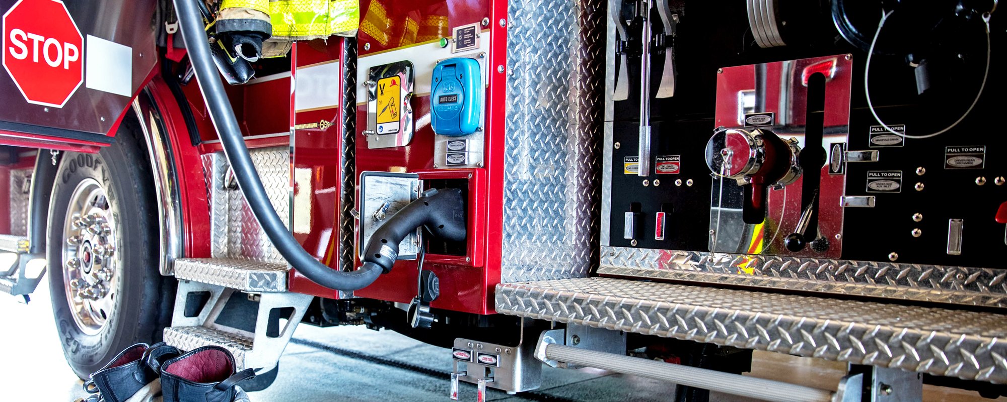 Pierce Volterra electric vehicle parked in fire station plugged in connecting to the charging station. 